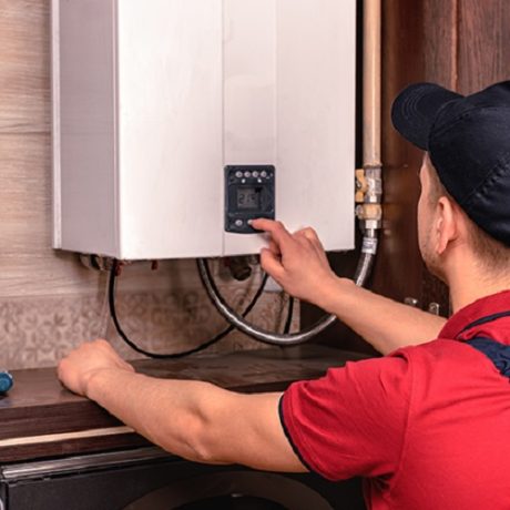 Plumber adjusts gas boiler before operating