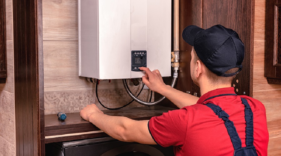 Plumber adjusts gas boiler before operating